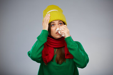 Sick woman in yellow hat touching her head with headache isolated portrait.