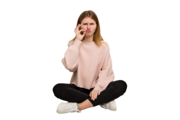 Young caucasian woman sitting on the floor cutout isolated
