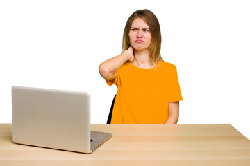 Young caucasian woman in a workplace working with a laptop isolated touching back of head, thinking and making a choice.