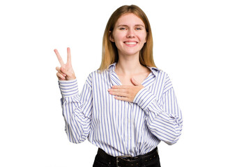 Young caucasian woman isolated taking an oath, putting hand on chest.