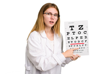 Young caucasian oculist woman holding a eye chart paper isolated