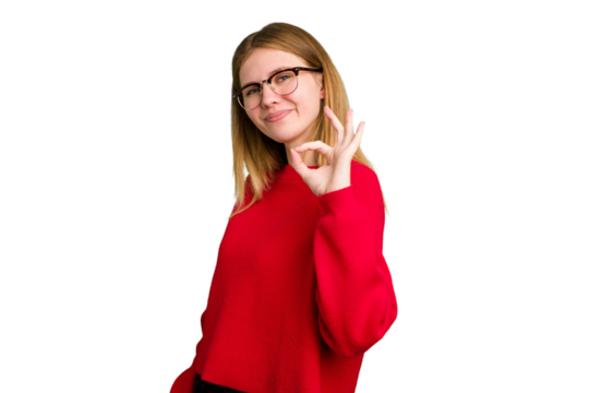 Young caucasian woman isolated winks an eye and holds an okay gesture with hand.