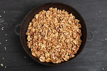 Walnut background. Peeled walnuts on a iron plate on black. walnuts a real super food full of vitamins and vegetable fats