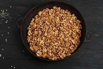 Walnut background. Peeled walnuts on a iron plate on black. walnuts a real super food full of vitamins and vegetable fats