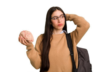 Young caucasian student woman holding a brain isolated touching back of head, thinking and making a choice.