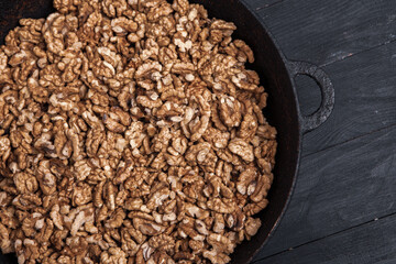 Walnut background. Peeled walnuts on a iron plate on black. walnuts a real super food full of vitamins and vegetable fats