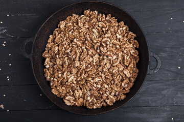 Walnut background. Peeled walnuts on a iron plate on black. walnuts a real super food full of vitamins and vegetable fats