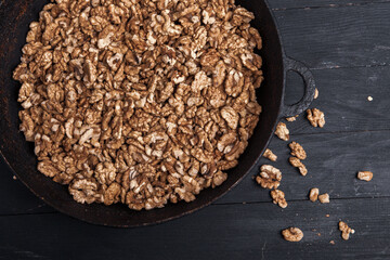 Walnut background. Peeled walnuts on a iron plate on black. walnuts a real super food full of vitamins and vegetable fats
