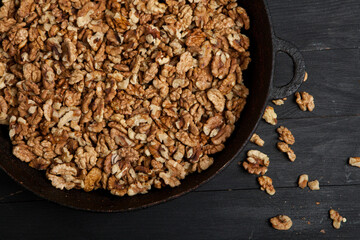 Walnut background. Peeled walnuts on a iron plate on black. walnuts a real super food full of vitamins and vegetable fats