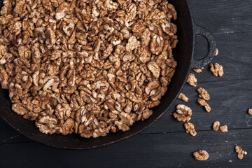 Walnut background. Peeled walnuts on a iron plate on black. walnuts a real super food full of vitamins and vegetable fats