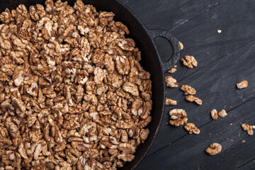 Walnut background. Peeled walnuts on a iron plate on black. walnuts a real super food full of vitamins and vegetable fats