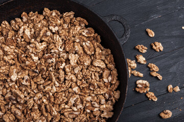 Walnut background. Peeled walnuts on a iron plate on black. walnuts a real super food full of vitamins and vegetable fats