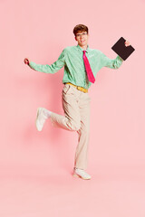 Funny emotional man, student geek wearing vintage style shirt and trousers having fun, using tablet...