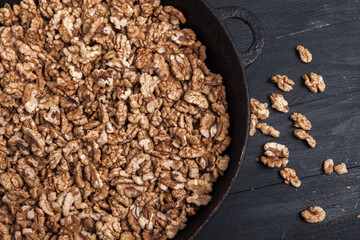 Walnut background. Peeled walnuts on a iron plate on black. walnuts a real super food full of vitamins and vegetable fats