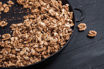 Walnut background. Peeled walnuts on a iron plate on black. walnuts a real super food full of vitamins and vegetable fats