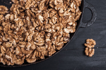 Walnut background. Peeled walnuts on a iron plate on black. walnuts a real super food full of vitamins and vegetable fats