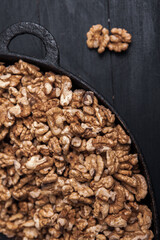 Walnut background. Peeled walnuts on a iron plate on black. walnuts a real super food full of vitamins and vegetable fats