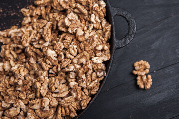 Walnut background. Peeled walnuts on a iron plate on black. walnuts a real super food full of vitamins and vegetable fats