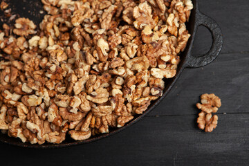 Walnut background. Peeled walnuts on a iron plate on black. walnuts a real super food full of vitamins and vegetable fats