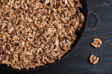 Walnut background. Peeled walnuts on a iron plate on black. walnuts a real super food full of vitamins and vegetable fats