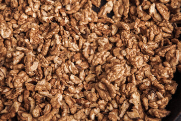 Walnut background. Peeled walnuts on a iron plate on black. walnuts a real super food full of vitamins and vegetable fats