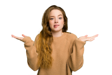 Young caucasian redhead woman isolated confused and doubtful shrugging shoulders to hold a copy space.