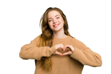 Young caucasian redhead woman isolated smiling and showing a heart shape with hands.