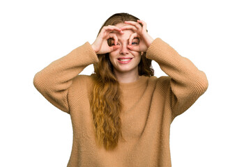 Young caucasian redhead woman isolated showing okay sign over eyes