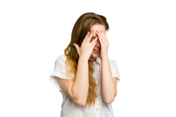 Young caucasian redhead woman isolated blink through fingers frightened and nervous.