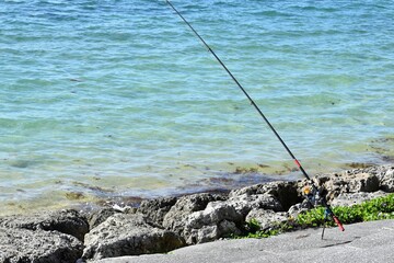 沖縄の海で釣りをする人の釣り竿リール竿