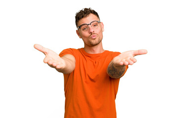 Fototapeta premium Young caucasian handsome man isolated folding lips and holding palms to send air kiss.