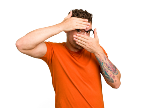 Young caucasian handsome man isolated blink at the camera through fingers, embarrassed covering face.