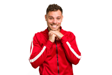 Young caucasian handsome man isolated keeps hands under chin, is looking happily aside.