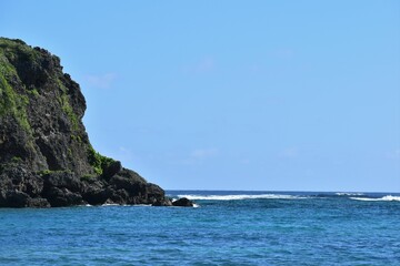 Fototapeta na wymiar 冬の沖縄の海岸の岩と青い海