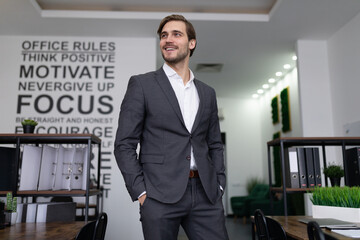 successful caucasian businessman inspects with a smile his office of a successful company