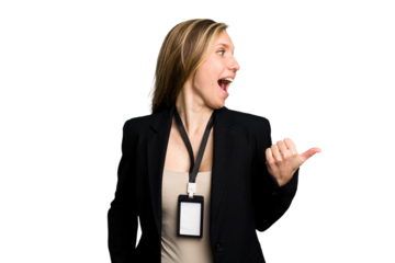 Young caucasian business woman with ID card isolated points with thumb finger away, laughing and carefree.