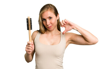 Young caucasian woman using an hair comb isolated feels proud and self confident, example to follow.