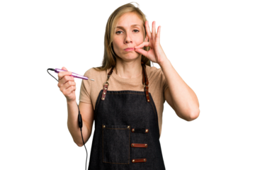 Young caucasian manicurist woman holding an electric file drill isolated with fingers on lips keeping a secret.