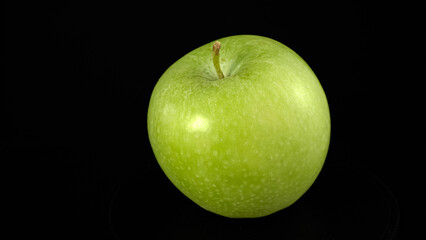 Green apple rotates. Close up fresh Green apple on black