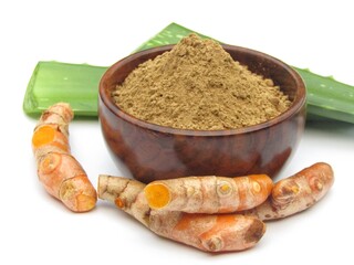 Aloe Vera powder in a bowl with turmeric root on white background 