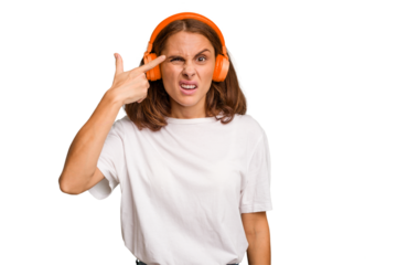 Young caucasian woman listening to music with headphones isolated showing a disappointment gesture with forefinger.