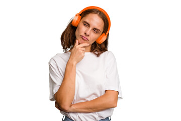 Young caucasian woman listening to music with headphones isolated looking sideways with doubtful...