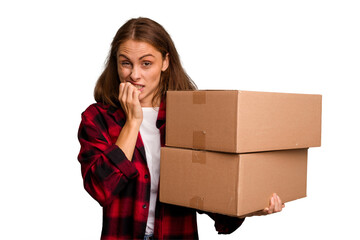 Young caucasian woman moving while picking up a box full of things isolated biting fingernails, nervous and very anxious.