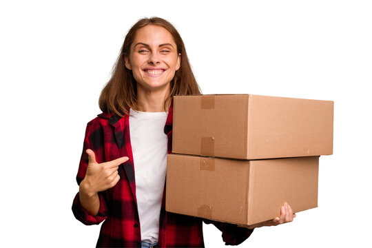 Young caucasian woman moving while picking up a box full of things isolated person pointing by hand to a shirt copy space, proud and confident