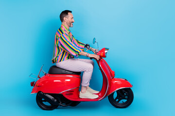 Fototapeta na wymiar Profile side photo of bearded mature glad man driving moped moving new road look empty space isolated on blue color background