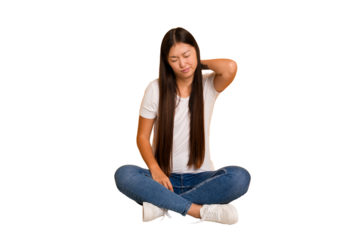 Young asian woman sitting on the floor cutout isolated having a neck pain due to stress, massaging and touching it with hand.