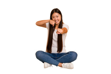 Young asian woman sitting on the floor cutout isolated throwing a punch, anger, fighting due to an...