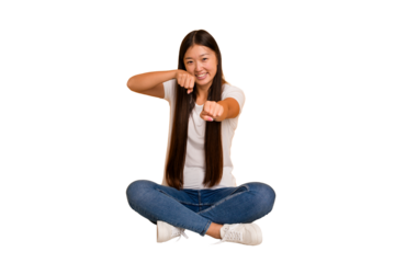 Young asian woman sitting on the floor cutout isolated throwing a punch, anger, fighting due to an argument, boxing.
