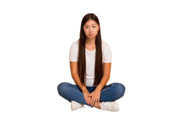 Young asian woman sitting on the floor cutout isolated sad, serious face, feeling miserable and displeased.