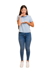 Young asian woman standing, full body cutout isolated holding something with both hands, product presentation.
